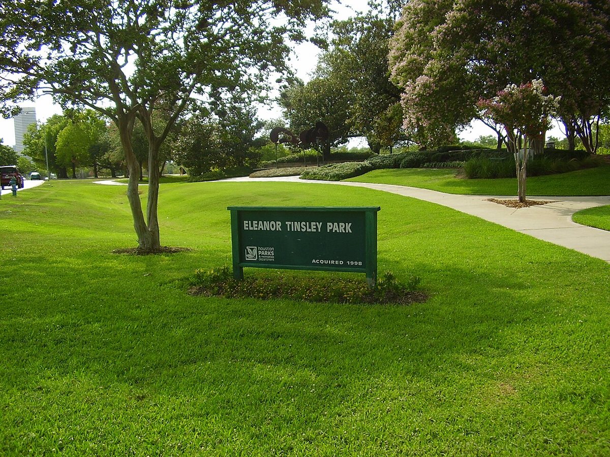 Open lawn at Eleanor Tinsley Park with the downtown Houston skyline visible in the distance